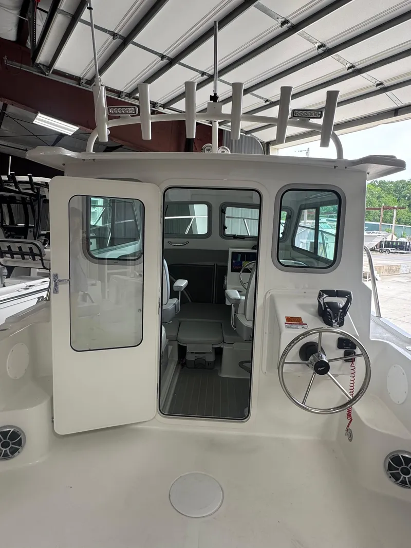 Slide: The Image of 2025 Parker 2420 Sport Cabin boat interior with steering wheel and seating. - 9