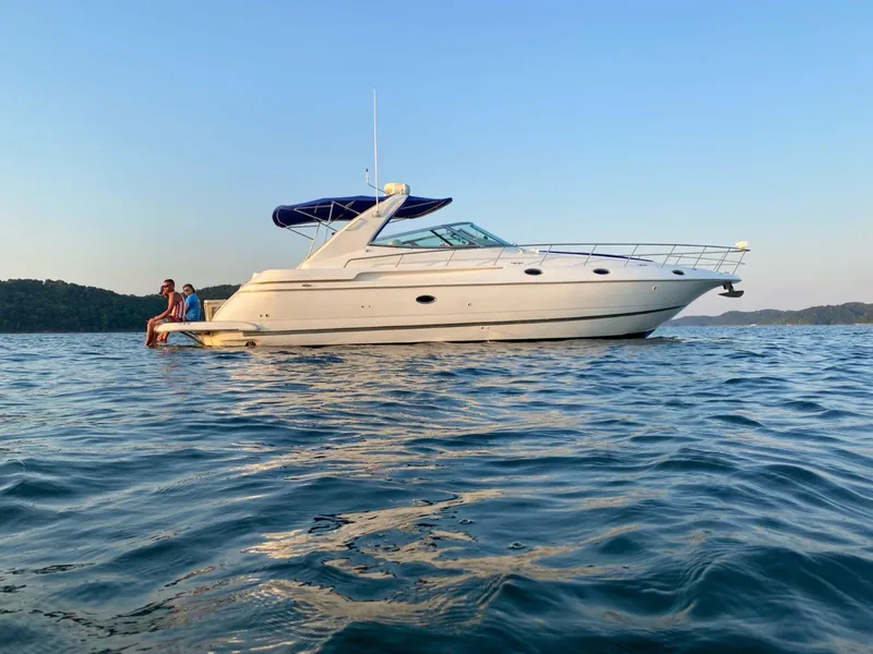 The Image of 2000 Cruisers Yachts 4270 Express on calm water at sunset. - 0