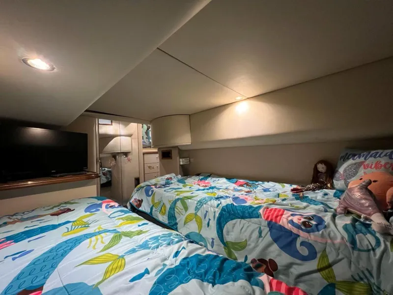 Slide: The Image of Cozy cabin interior of 2000 Cruisers Yachts 4270 Express with twin beds and colorful bedding. - 30