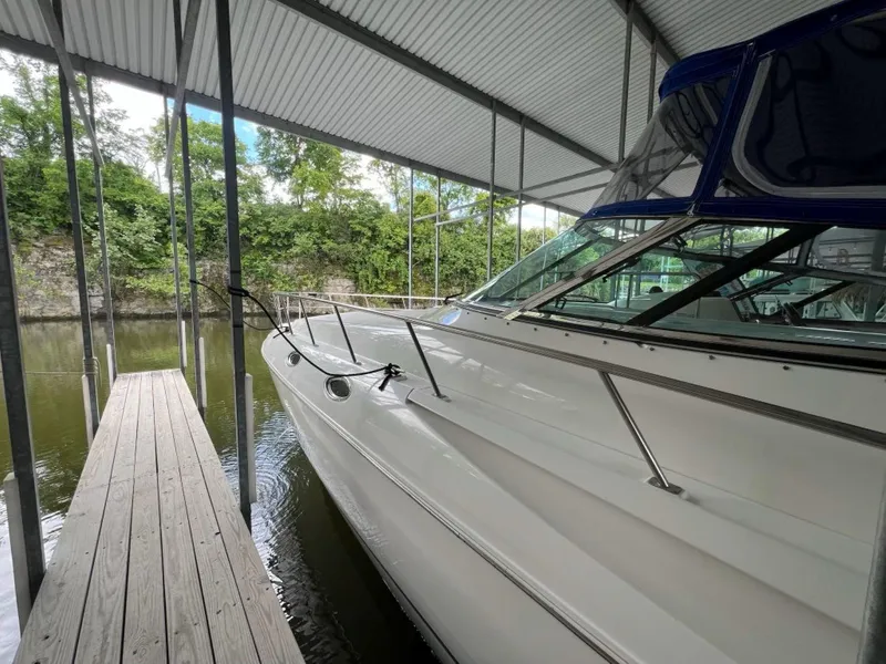 Slide: The Image of 2000 Cruisers Yachts 4270 Express docked under a covered marina. - 36