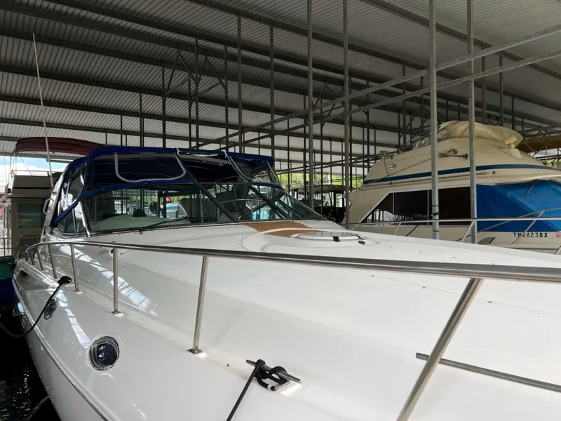 Slide: The Image of 2000 Cruisers Yachts 4270 Express docked in a covered marina. - 37