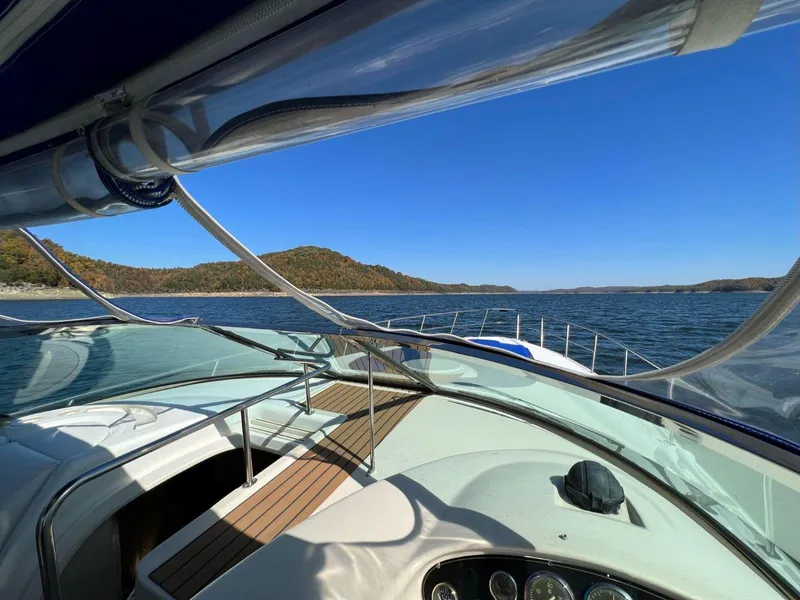 Slide: The Image of 2000 Cruisers Yachts 4270 Express on serene lake with clear blue sky. - 7