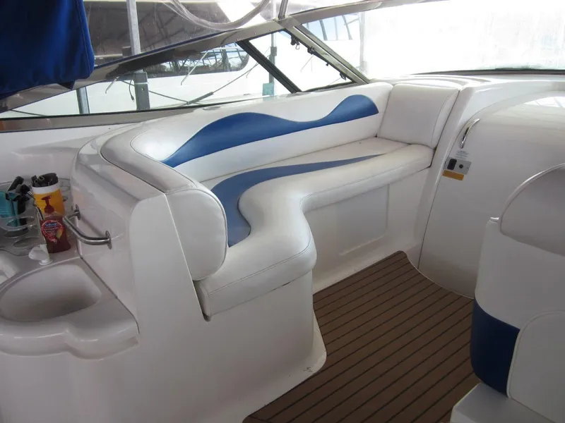 Slide: The Image of 2000 Cruisers Yachts 4270 Express interior with white and blue seating, wooden flooring. - 11