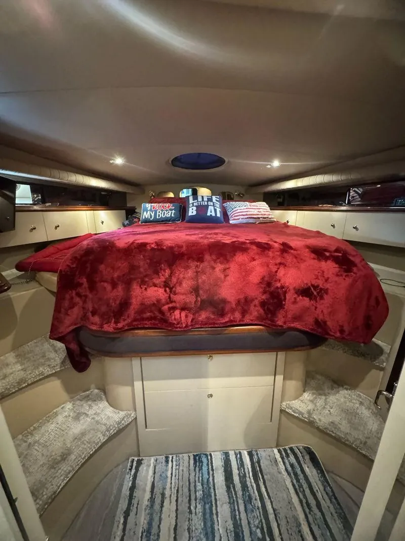 Slide: The Image of Luxurious 2000 Cruisers Yachts 4270 Express cabin with plush red bedding. - 17