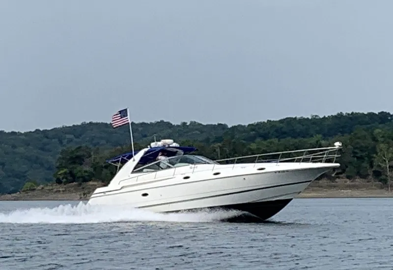 Slide: The Image of 2000 Cruisers Yachts 4270 Express cruising on a lake with American flag. - 2