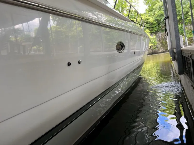 Slide: The Image of 2000 Cruisers Yachts 4270 Express docked, side view reflecting on calm water. - 40