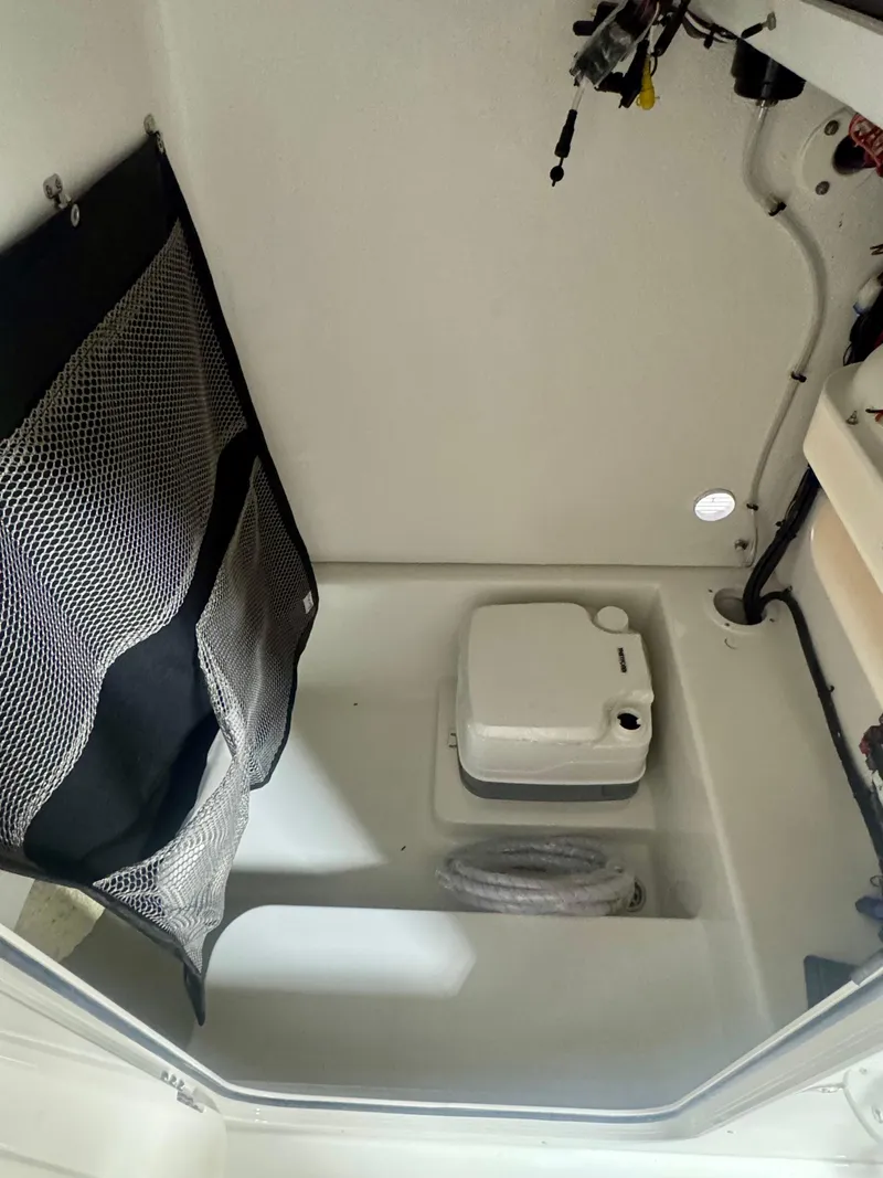 Slide: The Image of 2025 Parker 23SE Center Console interior with storage net and portable toilet. - 12