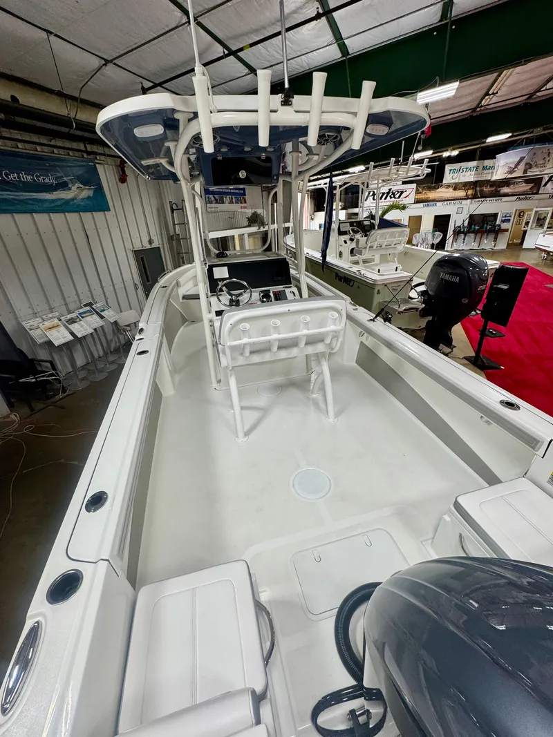Slide: The Image of 2025 Parker 23SE Center Console boat in showroom, featuring spacious deck and modern controls. - 6