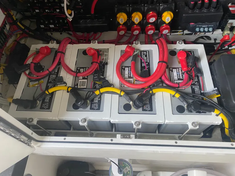 Slide: The Image of Four marine batteries with red and yellow cables in a 2022 Front Runner 36 cc boat. - 22
