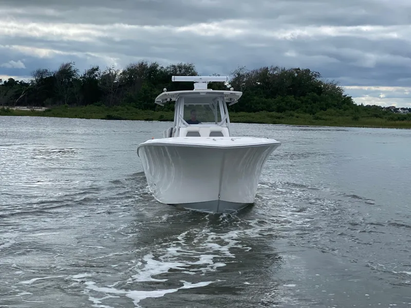 Slide: The Image of 2022 Front Runner 36 cc boat cruising on a calm waterway under cloudy skies. - 3