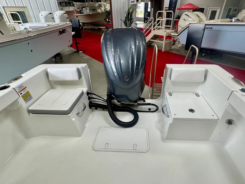 Slide: The Image of 2025 Parker 23SE Center Console boat interior with engine, showcased in a showroom. - 6