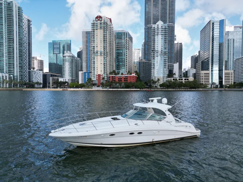 Slide: The Image of 2005 Sea Ray 44 Sundancer yacht on water with city skyline backdrop. - 0