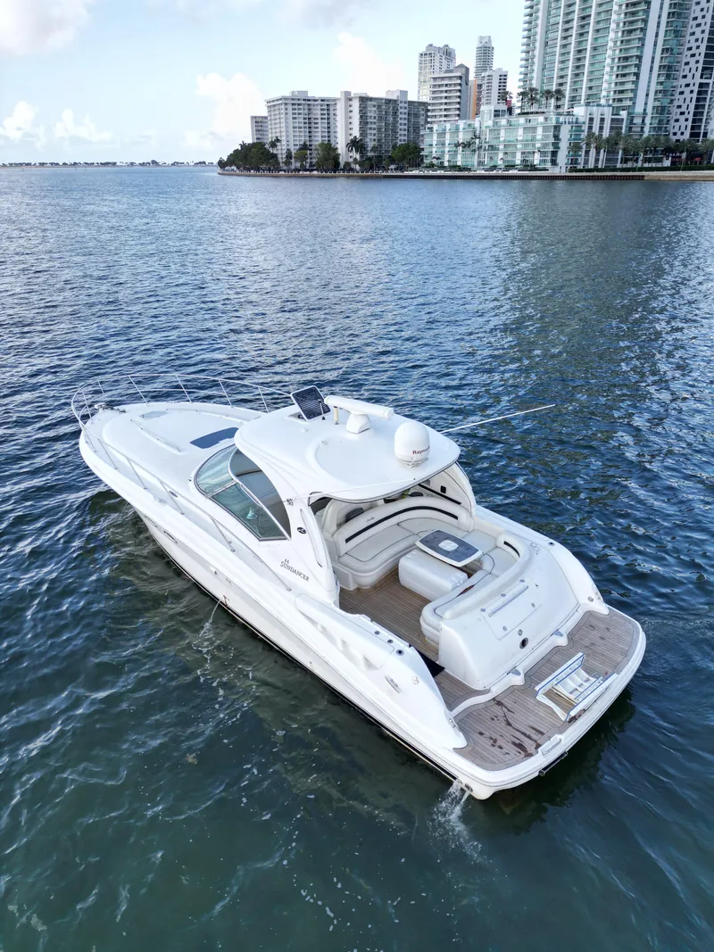 Slide: The Image of 2005 Sea Ray 44 Sundancer yacht cruising near city skyline on calm waters. - 12