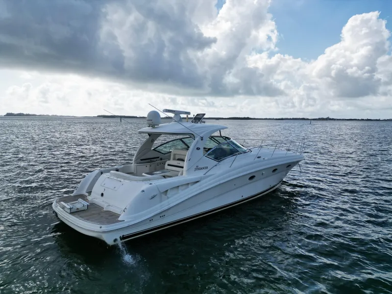 Slide: The Image of 2005 Sea Ray 44 Sundancer yacht cruising on open water under cloudy skies. - 2