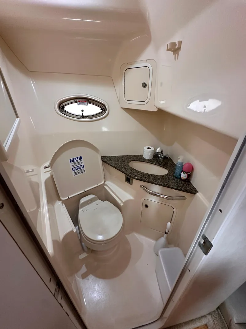 Slide: The Image of 2005 Sea Ray 44 Sundancer bathroom with toilet, sink, and porthole window. - 36