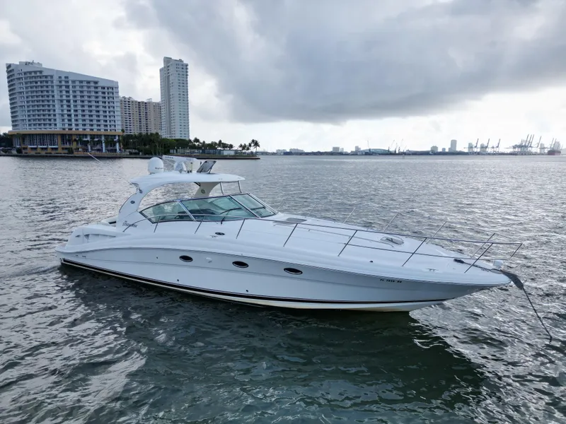 Slide: The Image of 2005 Sea Ray 44 Sundancer yacht on calm waters near city skyline. - 4