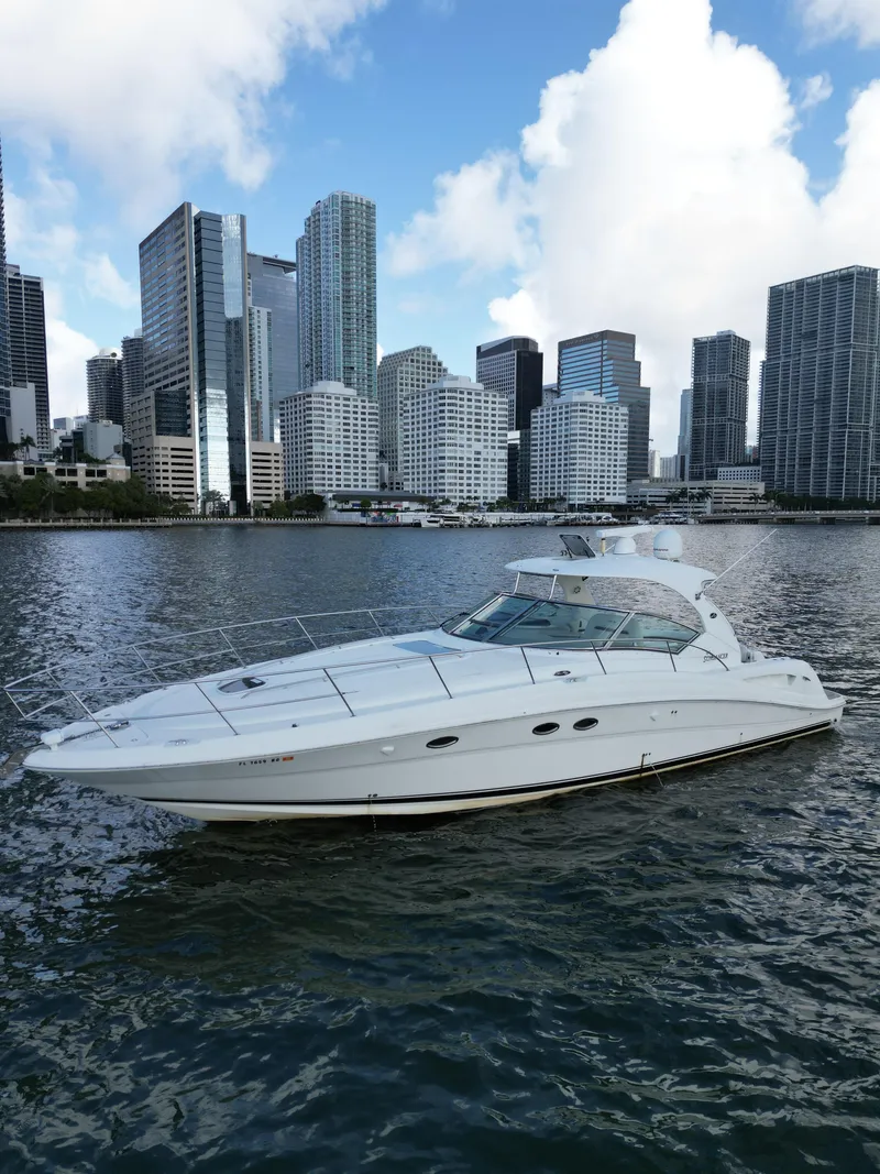 Slide: The Image of 2005 Sea Ray 44 Sundancer yacht cruising near city skyline under blue sky. - 9