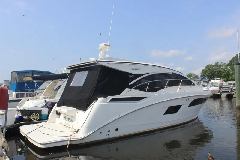 Slide: The Image of 2017 Sea Ray Sundancer 400 yacht docked at marina under clear blue sky. - 25