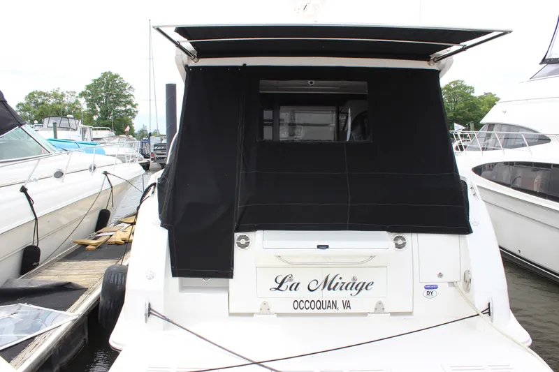 Slide: The Image of 2017 Sea Ray Sundancer 400 docked, rear view with black canopy, named "La Mirage." - 6
