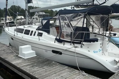 The Image of 2001 Hunter 340 sailboat docked at marina with canopy and sleek design. - 0