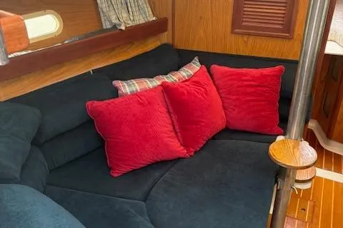 Slide: The Image of Interior of 2001 Hunter 340 sailboat with cozy seating and vibrant red cushions. - 11