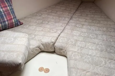 Slide: The Image of Interior cabin of 2001 Hunter 340 sailboat with patterned cushions and plaid pillow. - 12