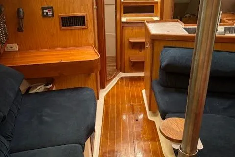 Slide: The Image of Interior of 2001 Hunter 340 sailboat with wooden flooring and blue seating. - 13
