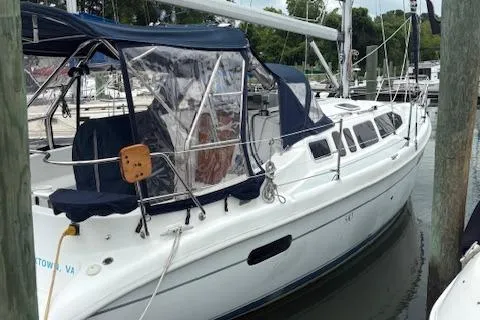 Slide: The Image of 2001 Hunter 340 sailboat docked at marina with blue canopy and clear panels. - 2