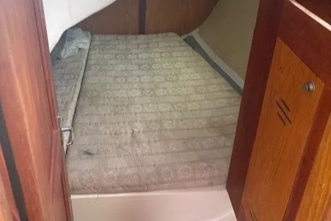 Slide: The Image of Interior cabin of 2001 Hunter 340 sailboat with a bed and wooden paneling. - 20