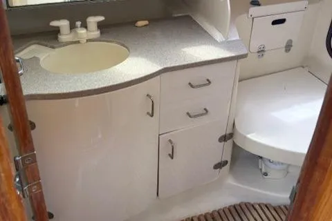 Slide: The Image of 2001 Hunter 340 yacht bathroom with sink, storage cabinets, and toilet. - 21