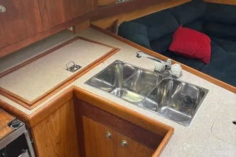 Slide: The Image of Kitchen area of a 2001 Hunter 340 sailboat with dual sinks and wooden cabinetry. - 8