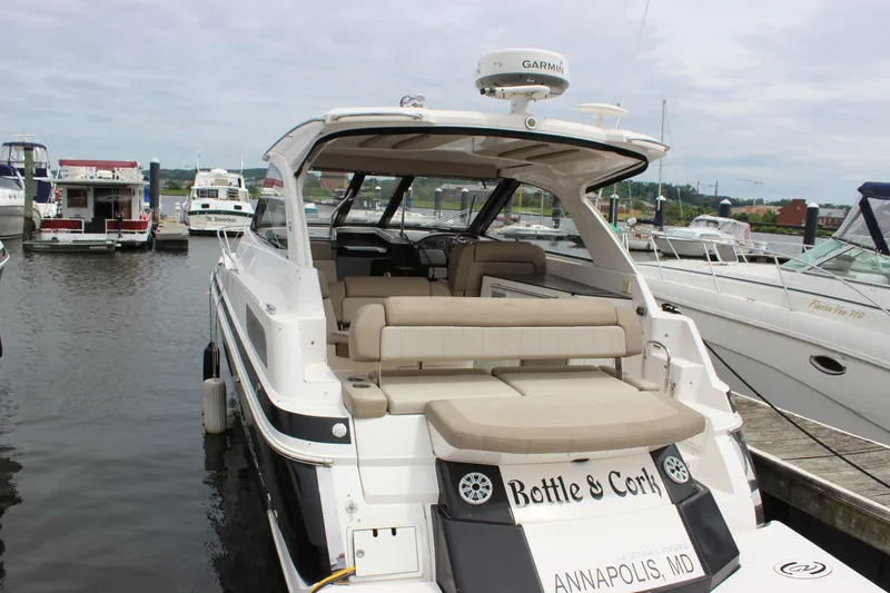 Slide: The Image of 2014 Regal 35 Sport Coupe docked in Annapolis marina, featuring spacious seating and modern design. - 23