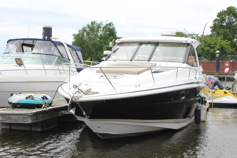 Slide: The Image of 2014 Regal 35 Sport Coupe docked at marina, surrounded by other boats. - 26
