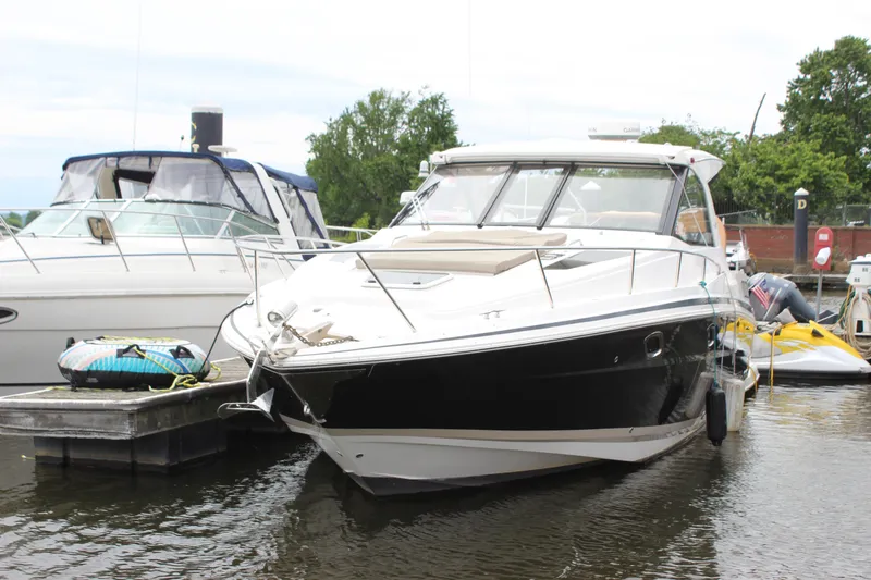 Slide: The Image of 2014 Regal 35 Sport Coupe docked at marina, surrounded by other boats. - 27