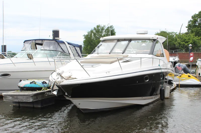 Slide: The Image of 2014 Regal 35 Sport Coupe docked at marina, sleek design, black and white exterior. - 28