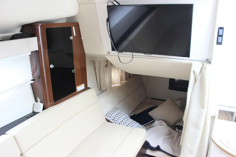 Slide: The Image of Interior of 2014 Regal 35 Sport Coupe with TV, seating, and cozy cabin area. - 32