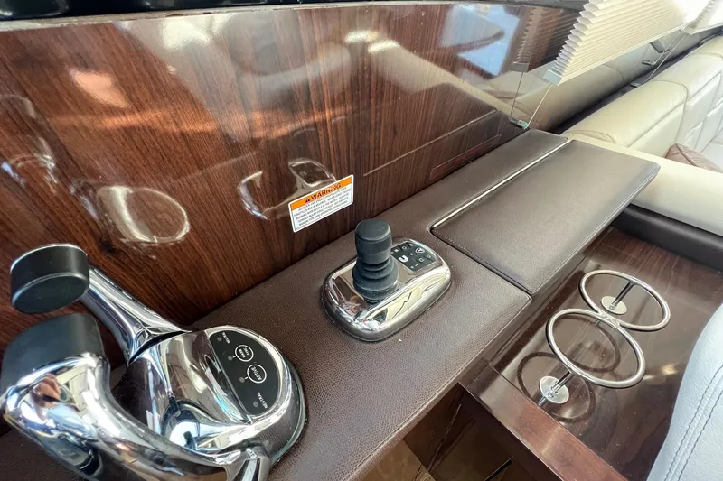 Slide: The Image of 2017 Sea Ray Sundancer 400 helm controls with joystick and cup holders. - 33