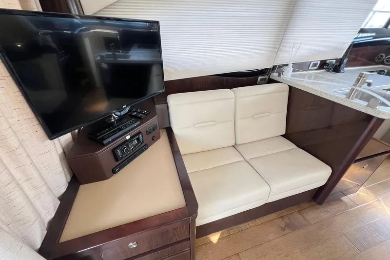 Slide: The Image of Interior of 2017 Sea Ray Sundancer 400 with TV, seating, and wood flooring. - 36