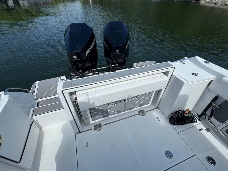 Slide: The Image of 2023 Blackfin 252 CC boat with dual Mercury engines on calm water. - 14