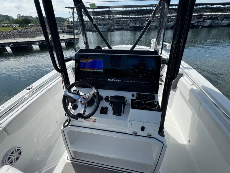 Slide: The Image of 2023 Blackfin 252 CC boat dashboard with steering wheel and navigation screens. - 7