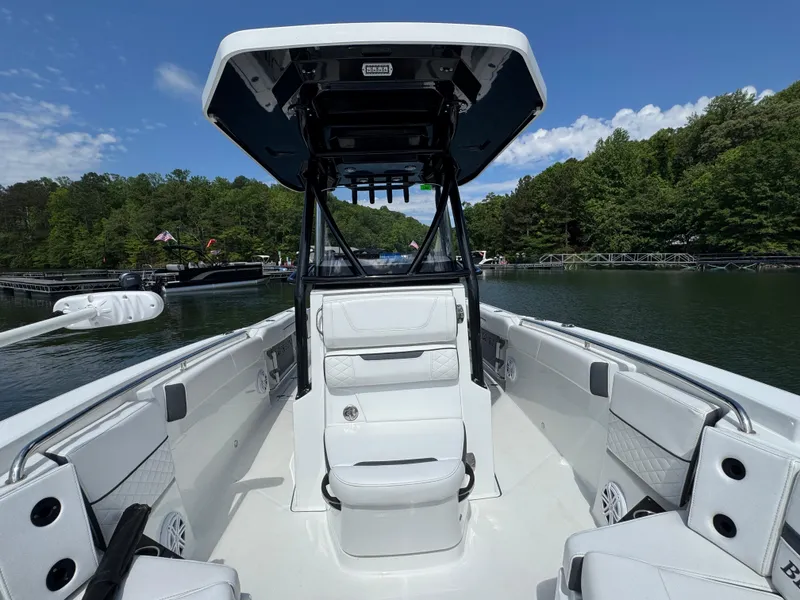 Slide: The Image of 2023 Blackfin 252 CC boat interior with seating, on a calm lake. - 8