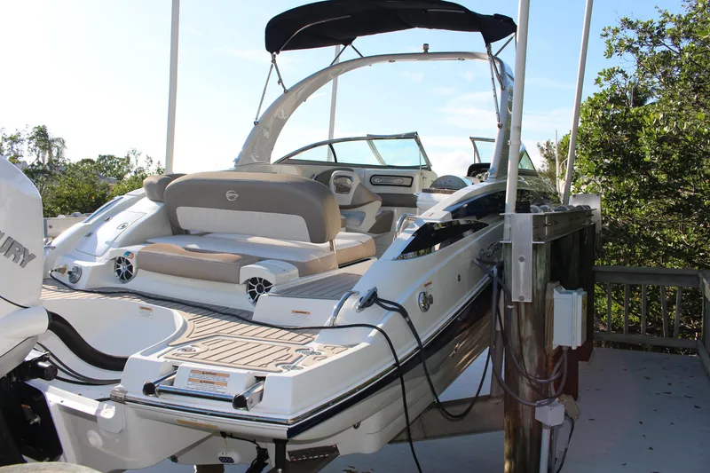 Slide: The Image of 2019 Crownline Eclipse E285 XS boat docked, featuring sleek design and spacious seating. - 0