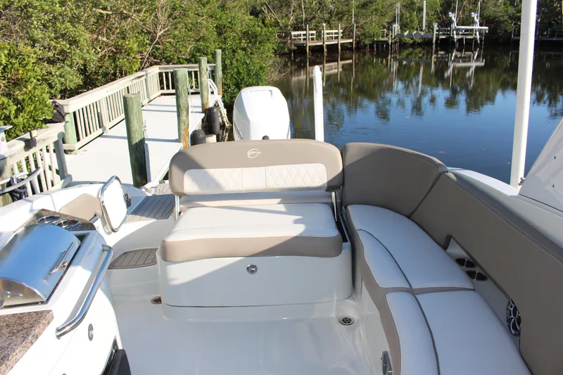 Slide: The Image of 2019 Crownline Eclipse E285 XS boat interior with seating, docked by a serene waterway. - 3