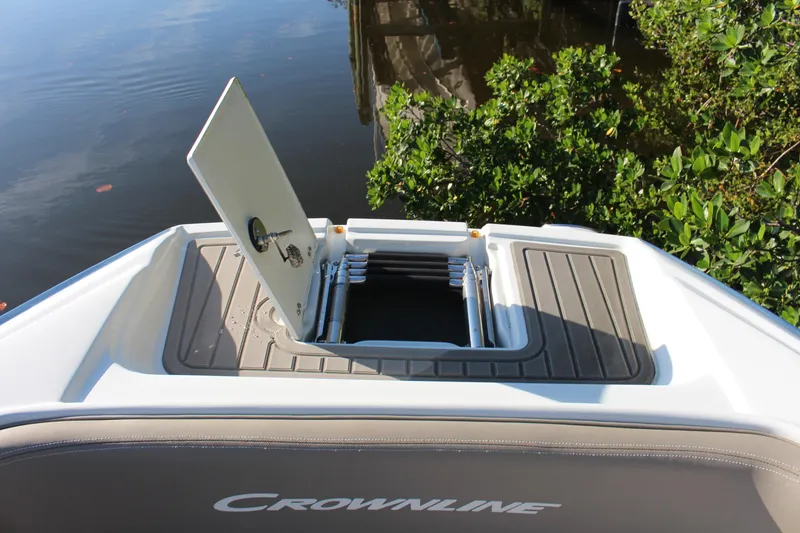 Slide: The Image of 2019 Crownline Eclipse E285 XS boat with open hatch, near water and greenery. - 6