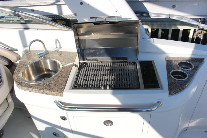 Slide: The Image of 2019 Crownline Eclipse E285 XS boat kitchenette with grill, sink, and cup holders. - 9