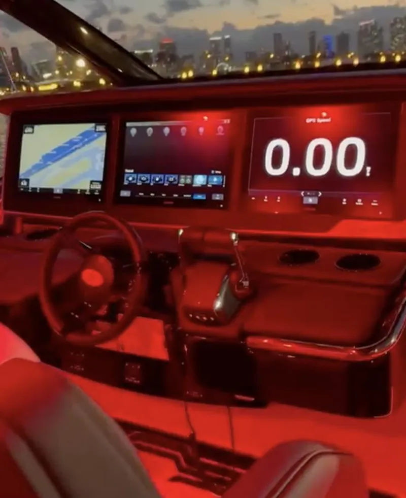 Slide: The Image of 2024 Cigarette 42 Auroris cockpit with illuminated digital displays and city skyline backdrop. - 10