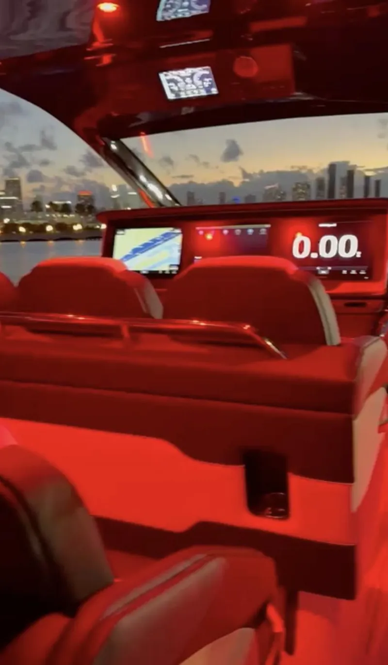Slide: The Image of 2024 Cigarette 42 Auroris boat interior with red lighting and digital dashboard. - 11