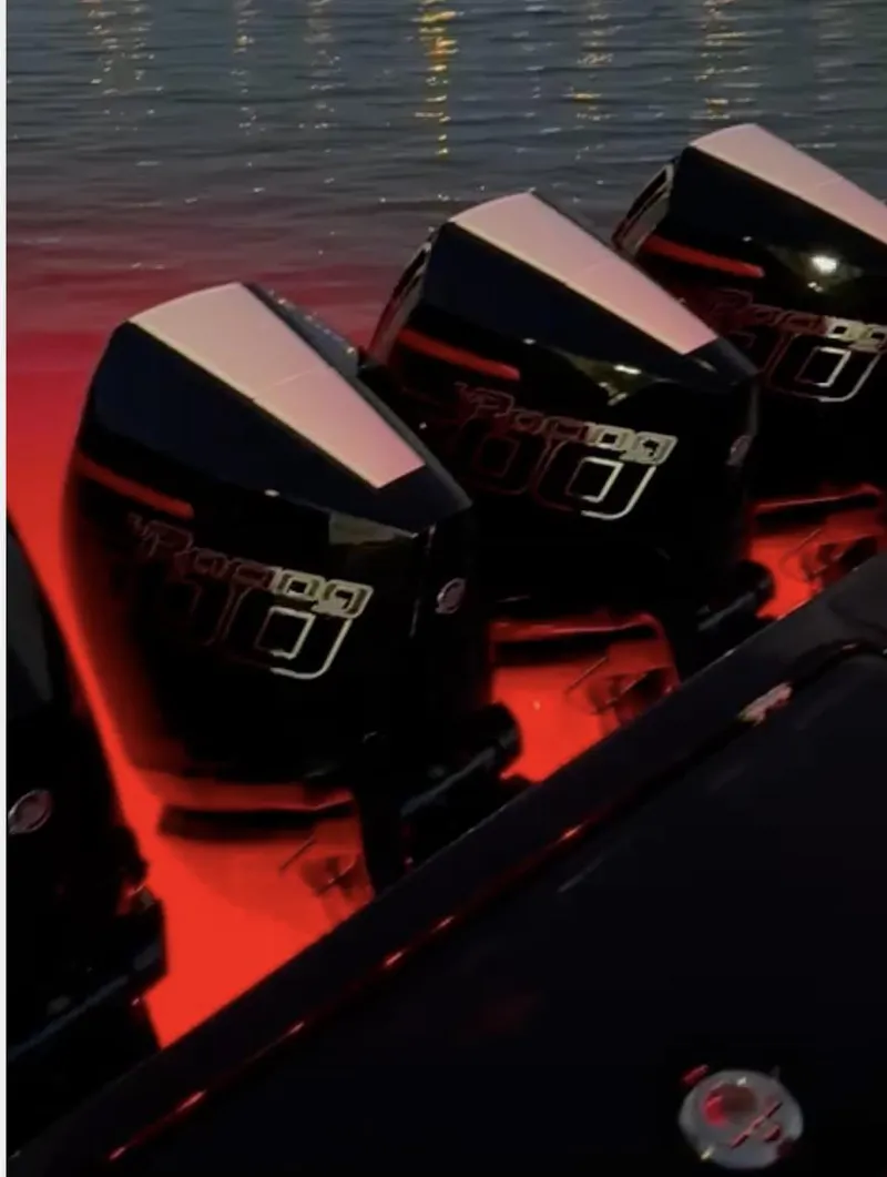 Slide: The Image of 2024 Cigarette 42 Auroris boat engines illuminated by red lights at night. - 12