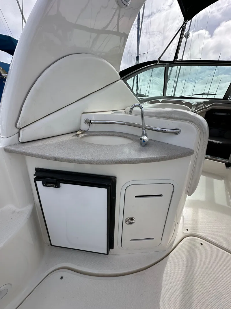 Slide: The Image of 2003 Sea Ray 320 Sundancer boat kitchenette with sink and storage. - 12
