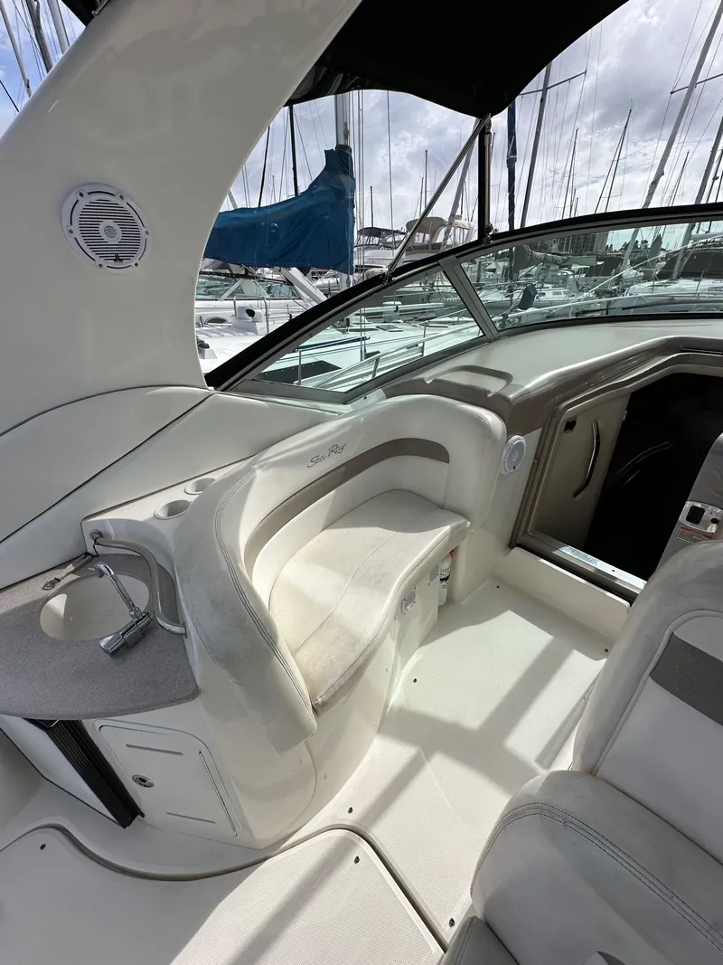 Slide: The Image of 2003 Sea Ray 320 Sundancer cockpit with seating, docked at marina. - 14